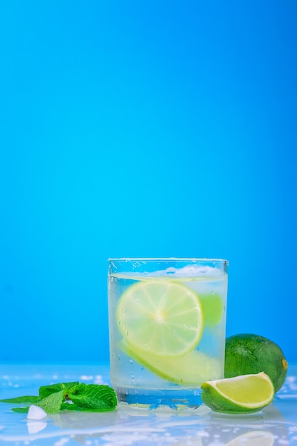 Cocktail Au Citron Vert Et Menthe Fraîche Dans Un Verre Sur Fond Bleu