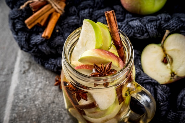 Cocktail D'automne. Infusion Diététique Infusée D'eau Aux Pommes Et épices Anis, Cannelle. Cocktail D'alcool Au Cidre De Pomme. En Pot De Maçon Sur Une Table En Pierre Noire.