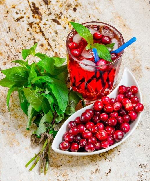 Cocktail aux canneberges. Cocktail de baies en verre avec de la glace et de la menthe sur la vieille table.