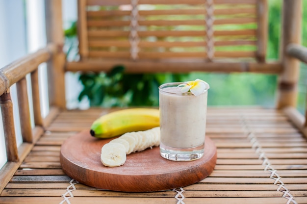 Cocktail de banane et bananes fraîches sur une table en bambou