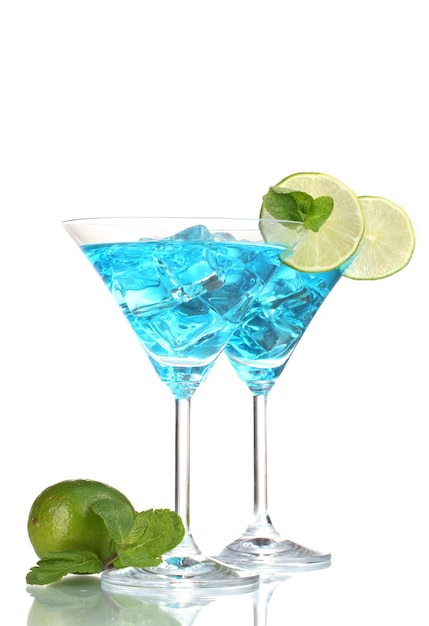 Cocktail bleu dans des verres à martini avec de la glace isolé sur blanc