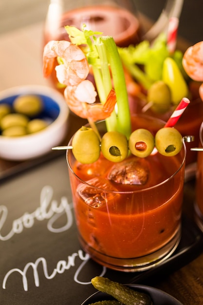 Cocktail Bloody Mary garni d'olives, de cornichons et de crevettes cocktail.