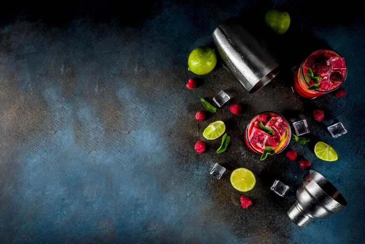 Photo cocktail de boissons estivales glacées, limonade à la framboise et au citron vert avec menthe fraîche et citron vert, table rouillée bleu foncé