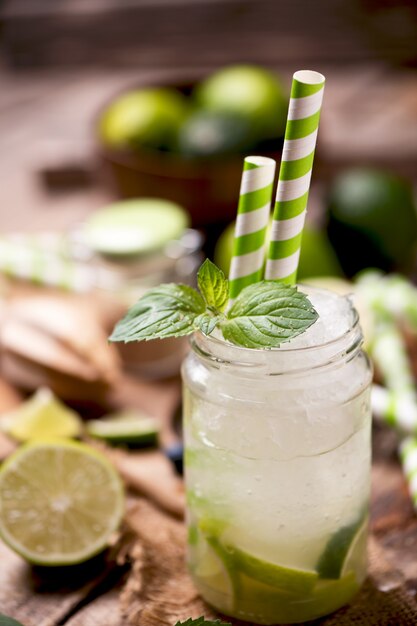 Cocktail Caipirinha dans un verre sur table en bois.