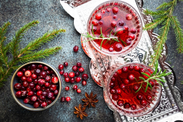 Cocktail de canneberges fraîches au romarin dans un verre sur la vue de dessus de fond gris