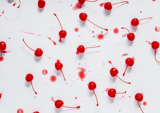 Cocktail de cerises au caramel avec des gouttes sur un mur blanc. Vue ci-dessus