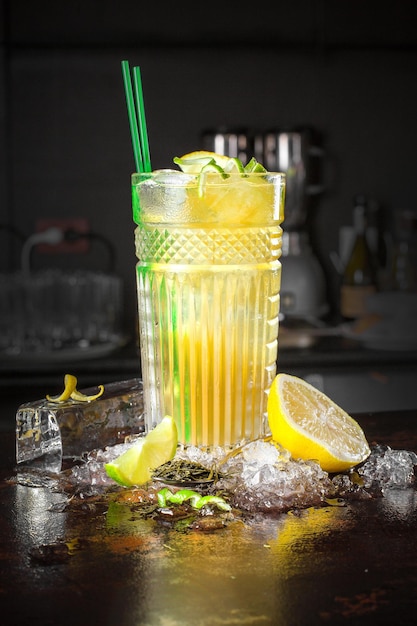 Cocktail avec citron et glaçons sur fond noir