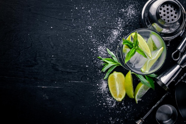 Cocktail citron vert et menthe avec de la glace sur une surface en bois noire Vue de dessus Espace libre