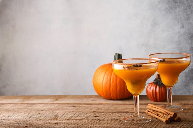 Cocktail de citrouille avec cannelle, jus d'orange et cacao dans des tasses en verre. Cocktail festif Margarita d'Halloween. Boisson d'automne à la citrouille pour Halloween ou Thanksgiving.