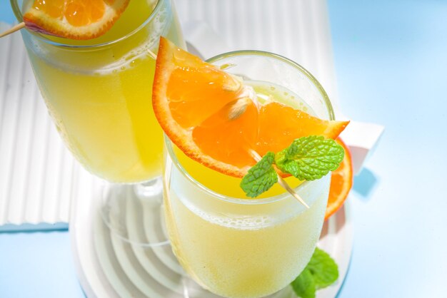 Cocktail classique de mimosas d'été, avec jus d'orange, sur fond bleu clair. Espace de copie de concept de menu de barre d'été