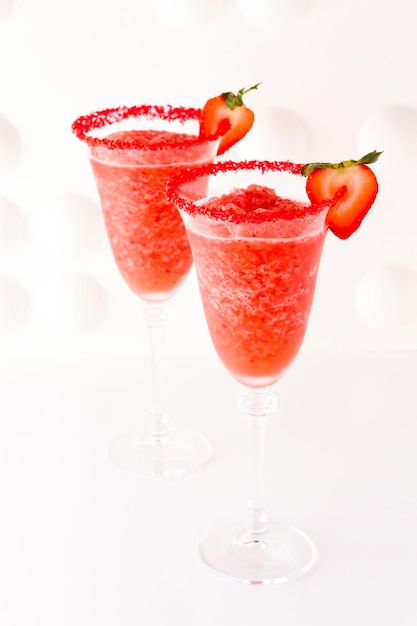 Cocktail daiquiri aux fraises avec fraise et citron vert en garniture.