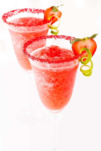 Cocktail daiquiri aux fraises avec fraise et citron vert en garniture.