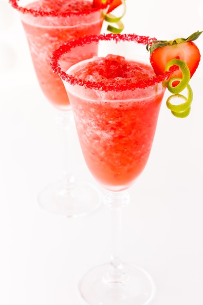 Cocktail daiquiri aux fraises avec fraise et citron vert en garniture.