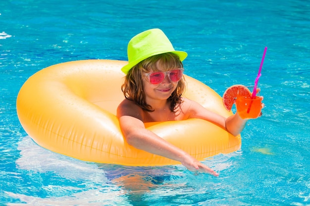 Cocktail dans la piscine l'enfant se repose dans la piscine avec une boisson aux fruits vacances d'été