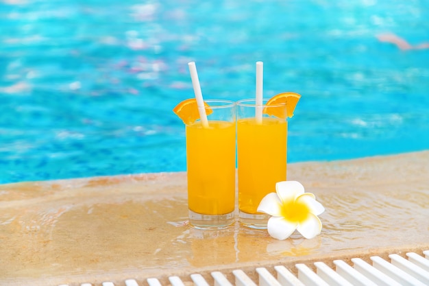 Cocktail dans un verre au bord de la piscine et fruits