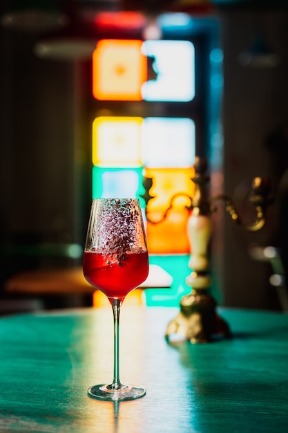 cocktail dans un verre à vin avec un glaçon