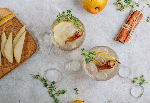 Cocktail épicé festif d'été avec poires et thym sur fond beige clair Vue de dessus