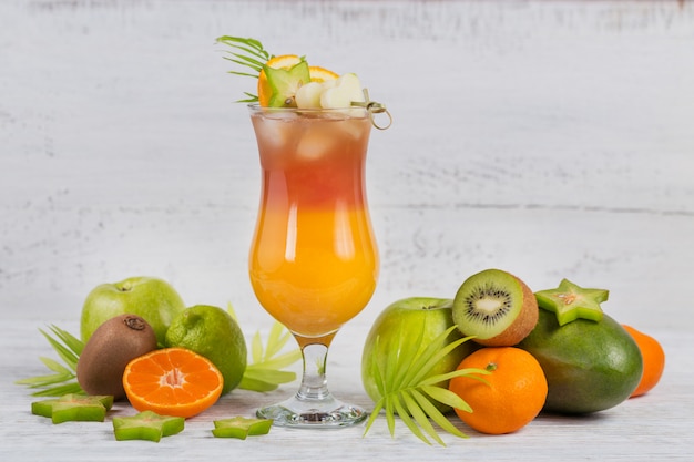 Cocktail d'été avec divers fruits tropicaux autour