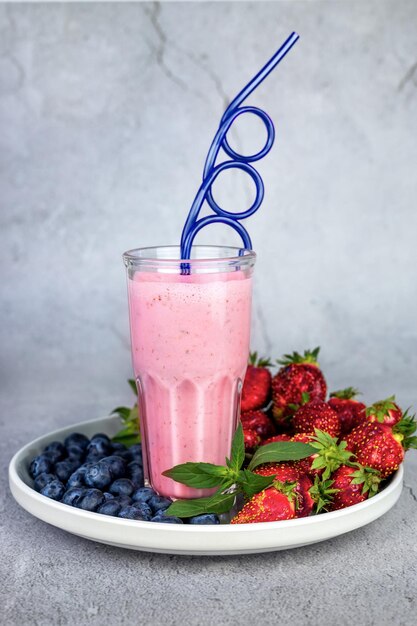 Cocktail de fraises dans un verre en verre sur une plaque grise avec des baies fraîches