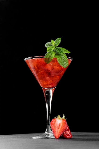 Cocktail de fraises d'été froid mojito margarita daiquiri dans un verre à martini sur fond sombre gros plan