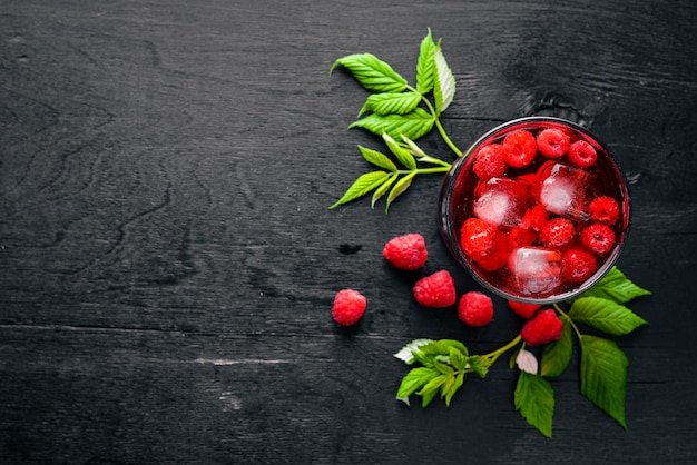 Cocktail de framboises fraîches avec de la glace sur un fond en bois Vue de dessus Espace libre