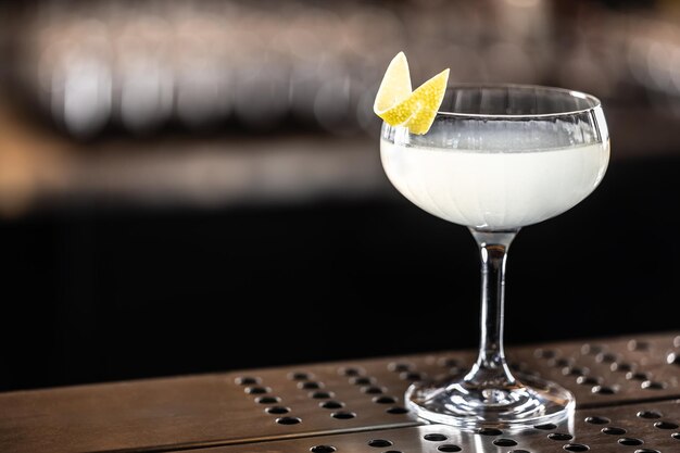 Cocktail français rafraîchissant 75 décoré avec de la peau de citron dans un verre au bar