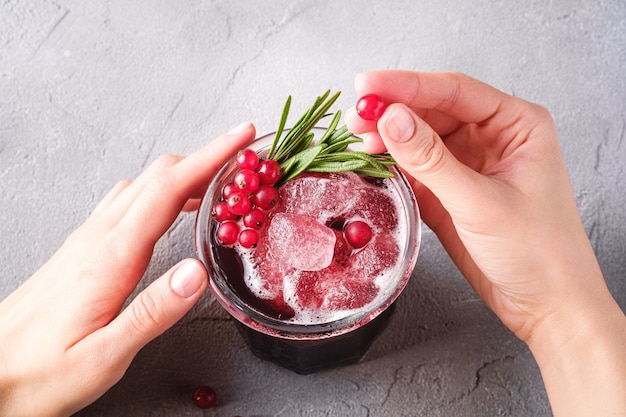 Cocktail de fruits frais froids en verre, boisson rafraîchissante aux baies de cassis d'été avec des feuilles de romarin