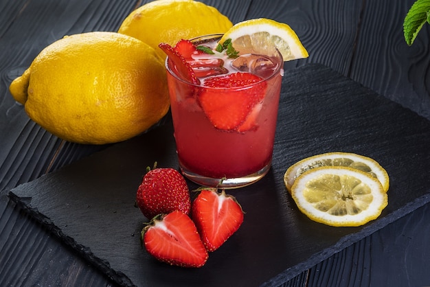 Cocktail de fruits avec fruits frais et glace. Dans des verres sur fond de bois noir rustique