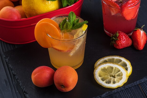 Cocktail de fruits avec fruits frais et glace. Dans des verres sur fond de bois noir rustique