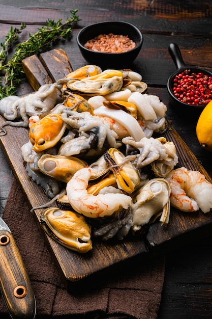 Cocktail de fruits de mer mélange cru avec crevettes, crevettes, moules, calmars, sur fond de table en bois foncé ancien