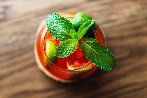 Cocktail de fruits rouges mélangé au citron et décoré de feuilles vertes de menthe fraîche.