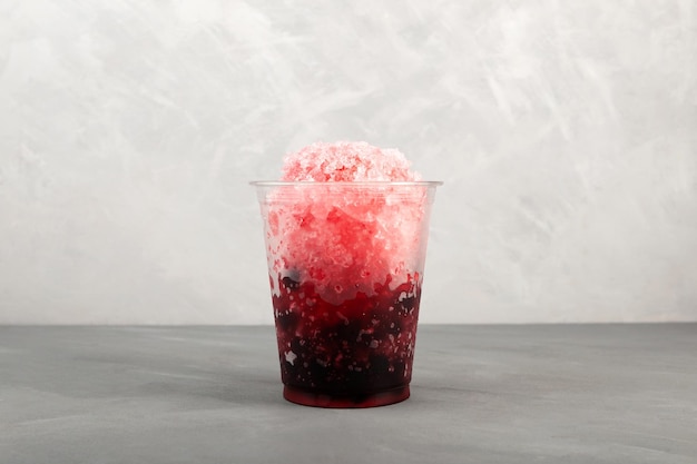 Cocktail glacé aux baies de fruits dans une tasse en plastique Slush Boisson rafraîchissante avec des perles de tapioca glace pilée