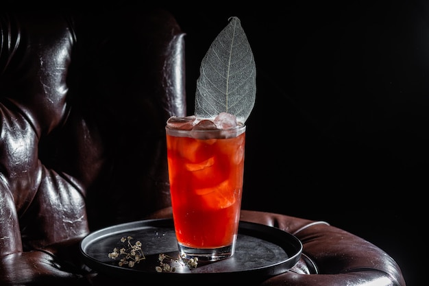 Cocktail avec glace sur fond sombre