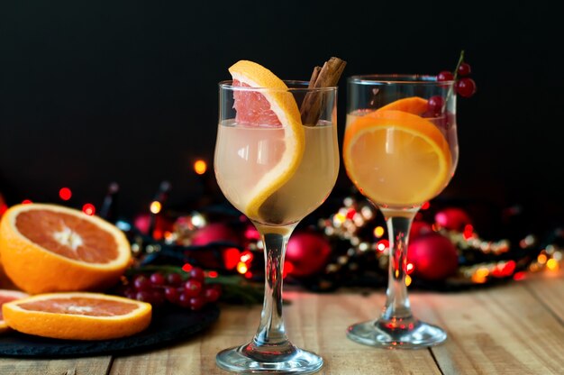 Cocktail d'hiver au pamplemousse, cannelle et groseille rouge dans des verres à vin.