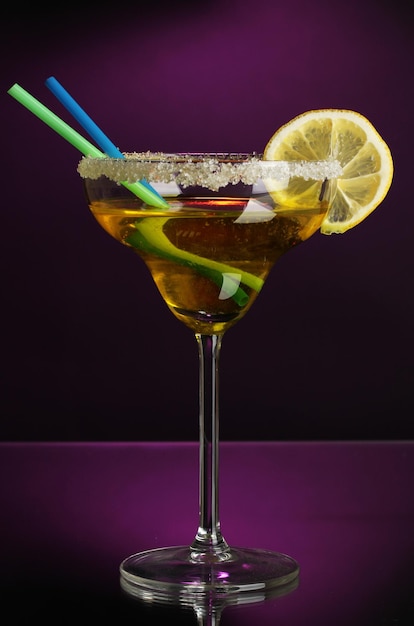 Cocktail jaune en verre sur fond de couleur