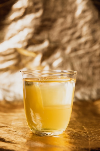 Un cocktail jaune vif avec de la glace dans un verre lowball