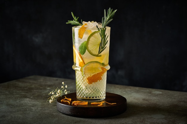 Cocktail de limonade d'été rafraîchissante maison avec jus d'orange glace pilée romarin et agrumes