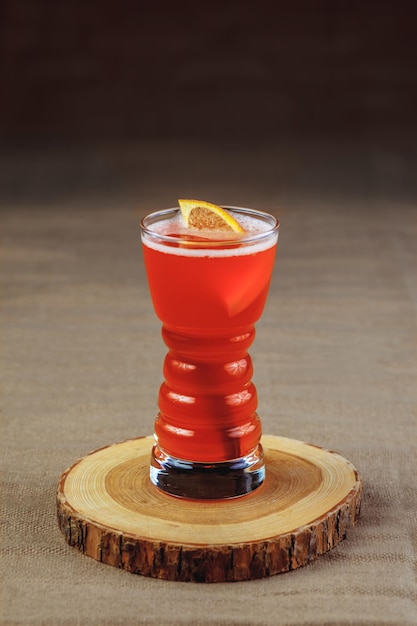 Cocktail lumineux sur un support en bois. Boisson alcoolisée rafraîchissante.