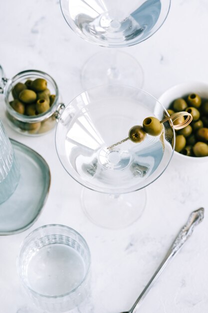 Cocktail Martini dans un verre sur fond blanc avec des olives