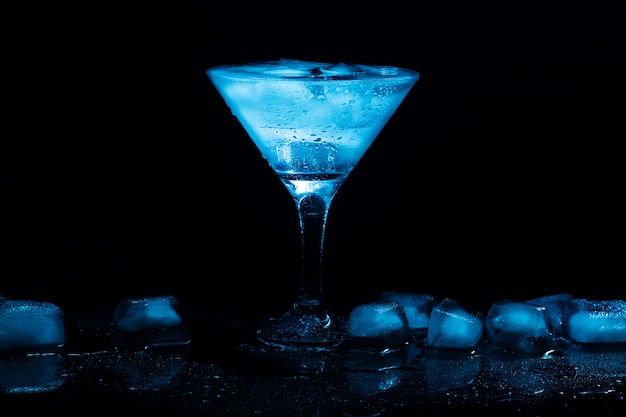Cocktail martini avec glace dans un verre sur tableau noir