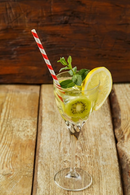 Cocktail à la menthe kiwi et au citron dans un verre sur une table en bois