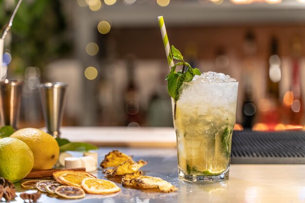 Cocktail Mojito sur le comptoir du bar avec des citrons, des citrons citrons et des espèces avec un espace de copie pour le texte