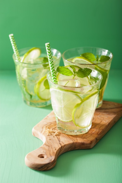 Cocktail de mojito et ingrédients sur fond vert