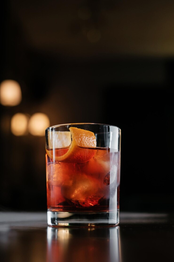 Cocktail Negroni avec de la croûte d'orange sur une table en bois