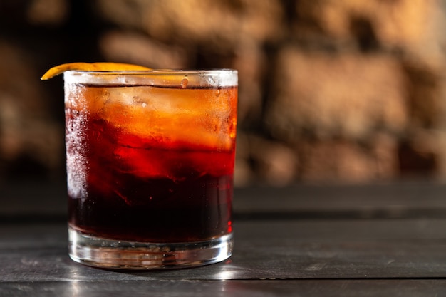 Cocktail Negroni sur une planche en bois. Cocktail Negroni au bar. Mise au point sélective