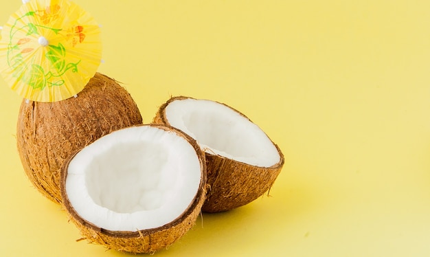 Cocktail de noix de coco fraîche avec une paille sur fond jaune, copiez l'espace.