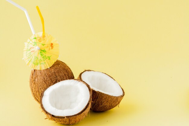 Cocktail de noix de coco fraîche avec une paille sur fond jaune, copiez l'espace.