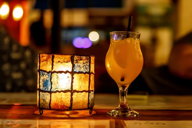 Cocktail d'orange au bar. Verre et lampe en forme de tulipe