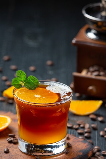 Cocktail d'orange et de café sur la surface sombre.