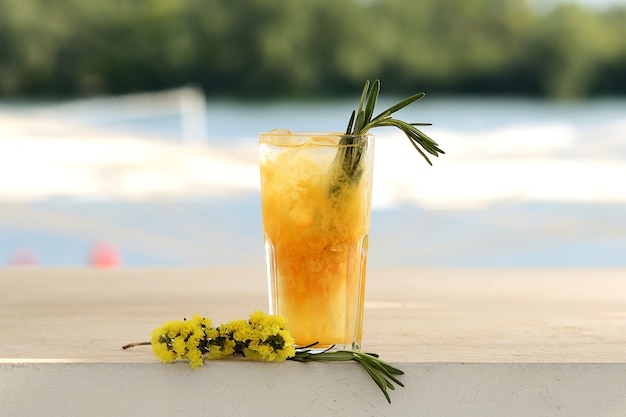 Cocktail orange dans un verre. Avec décor de fleurs